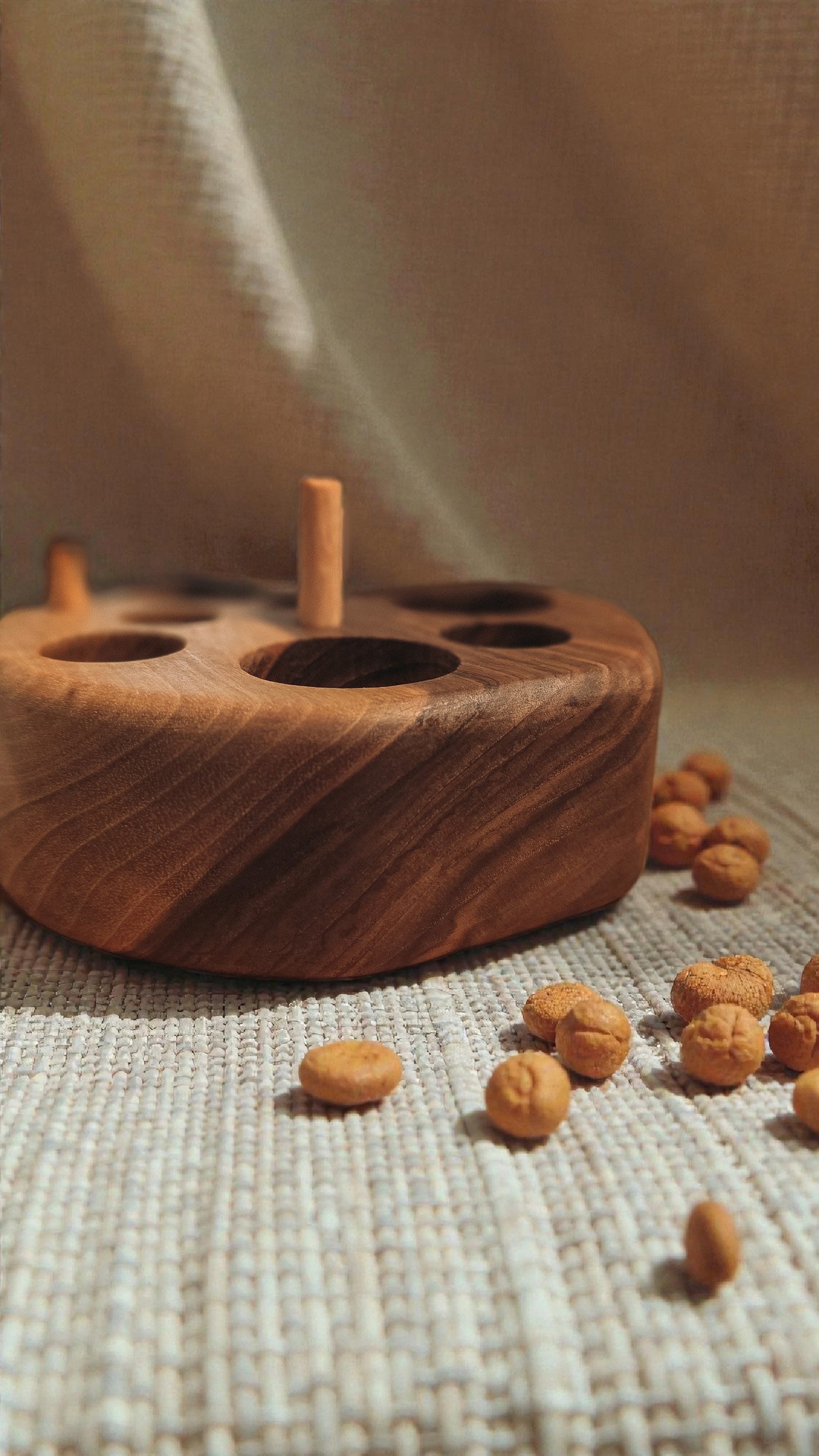 Wlnut wood cat feeding puzzle with linen background and cat kibble