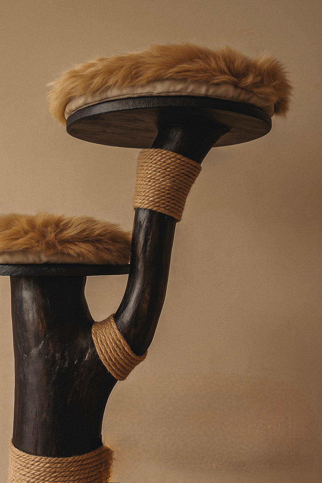 Cat tree with wooden branch, cushioned platforms, and rope, on a plain background