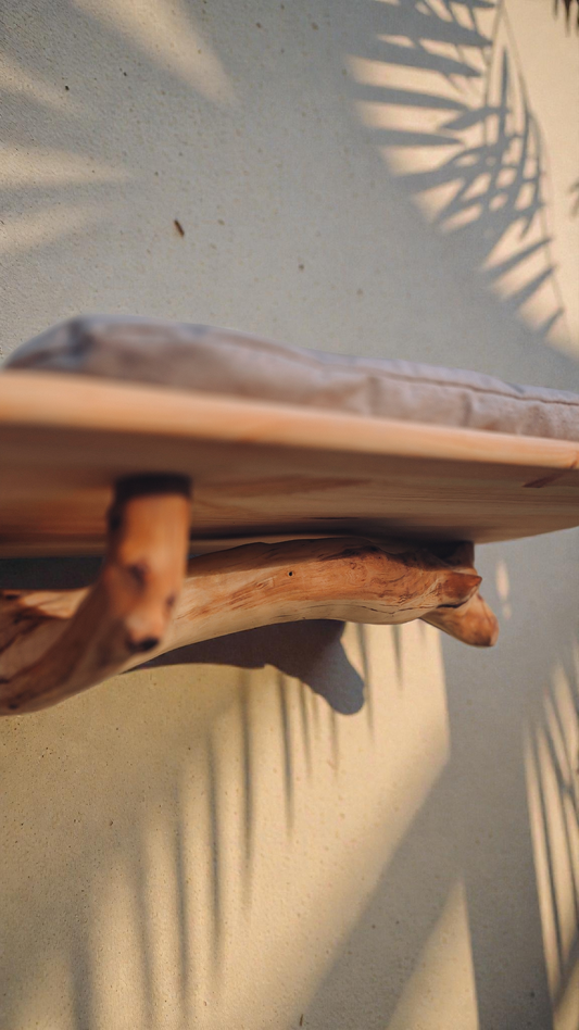 close up wooden wall mounted branch cat bed