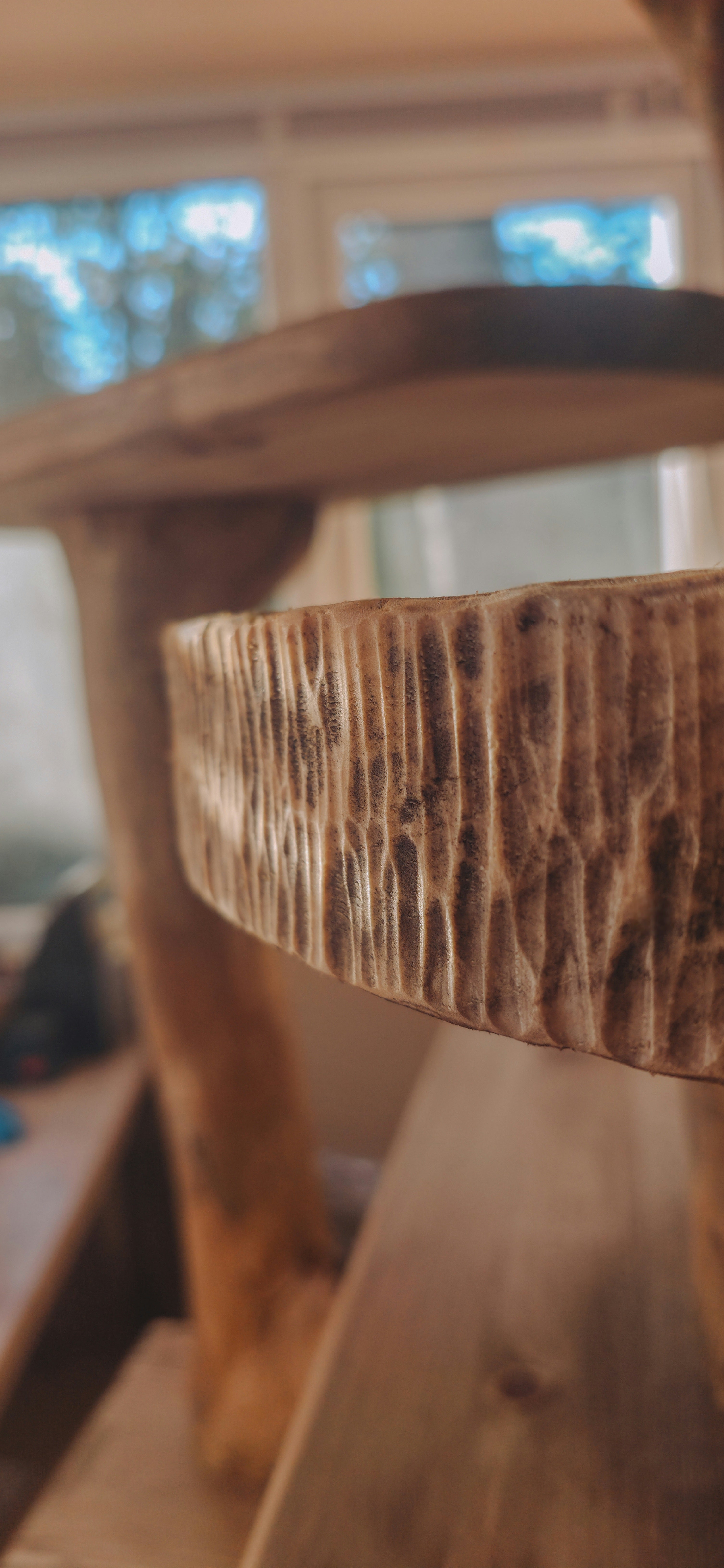 close up of hand carved wooden bowl bed for pets with blurred background
