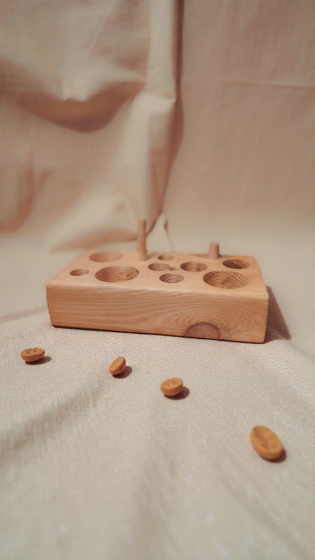 wooden cat feeding puzzle and chew toy with linen background