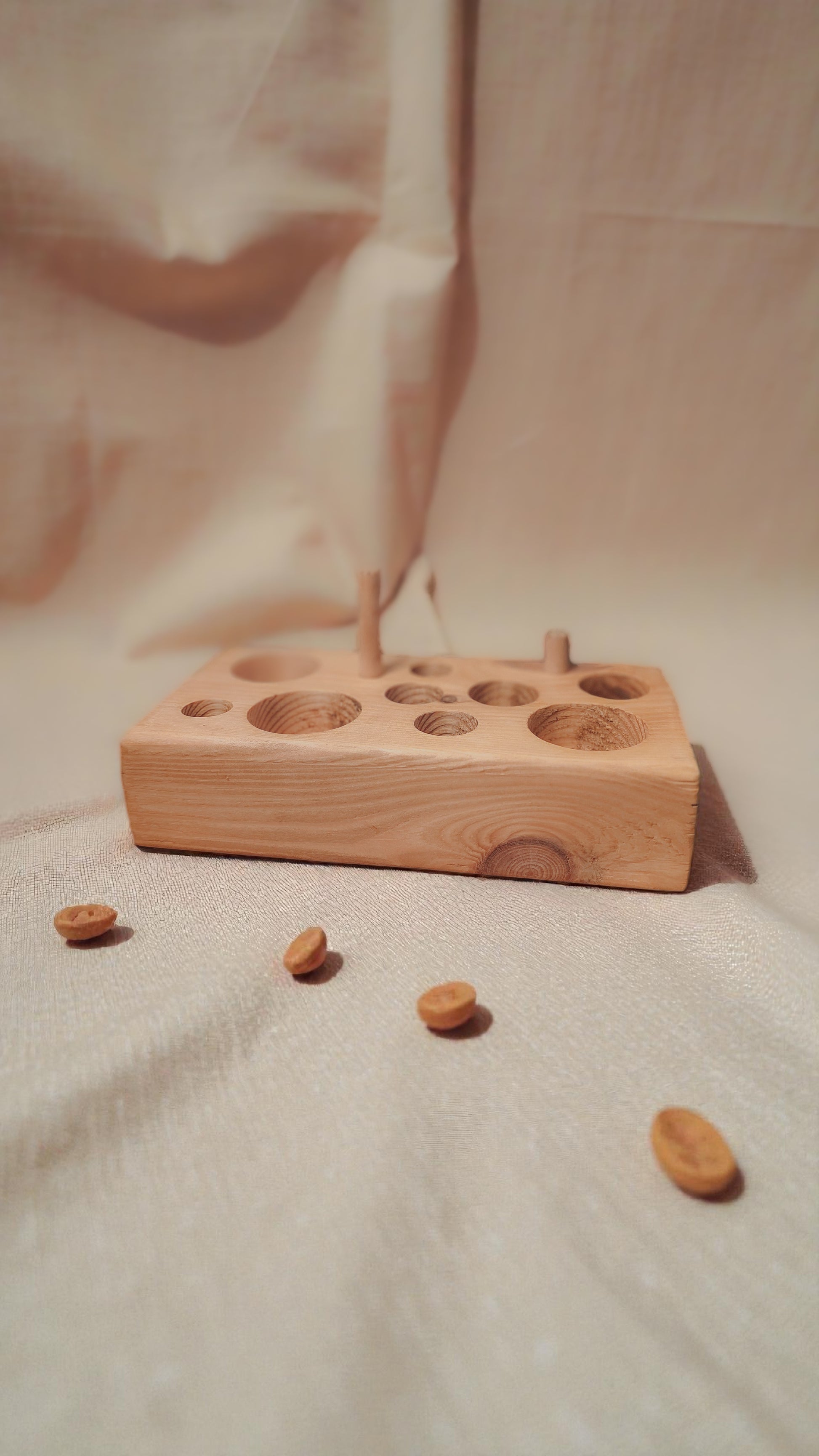 wooden cat feeding puzzle and chew toy with linen background