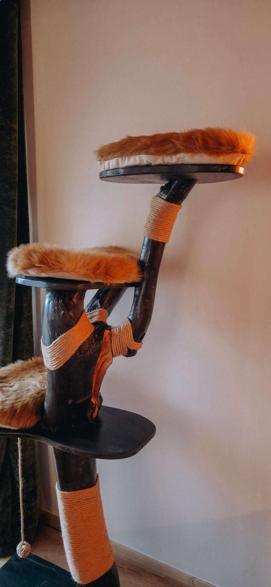 solid wood Cat tree with multiple platforms and a scratching post against a white wall.